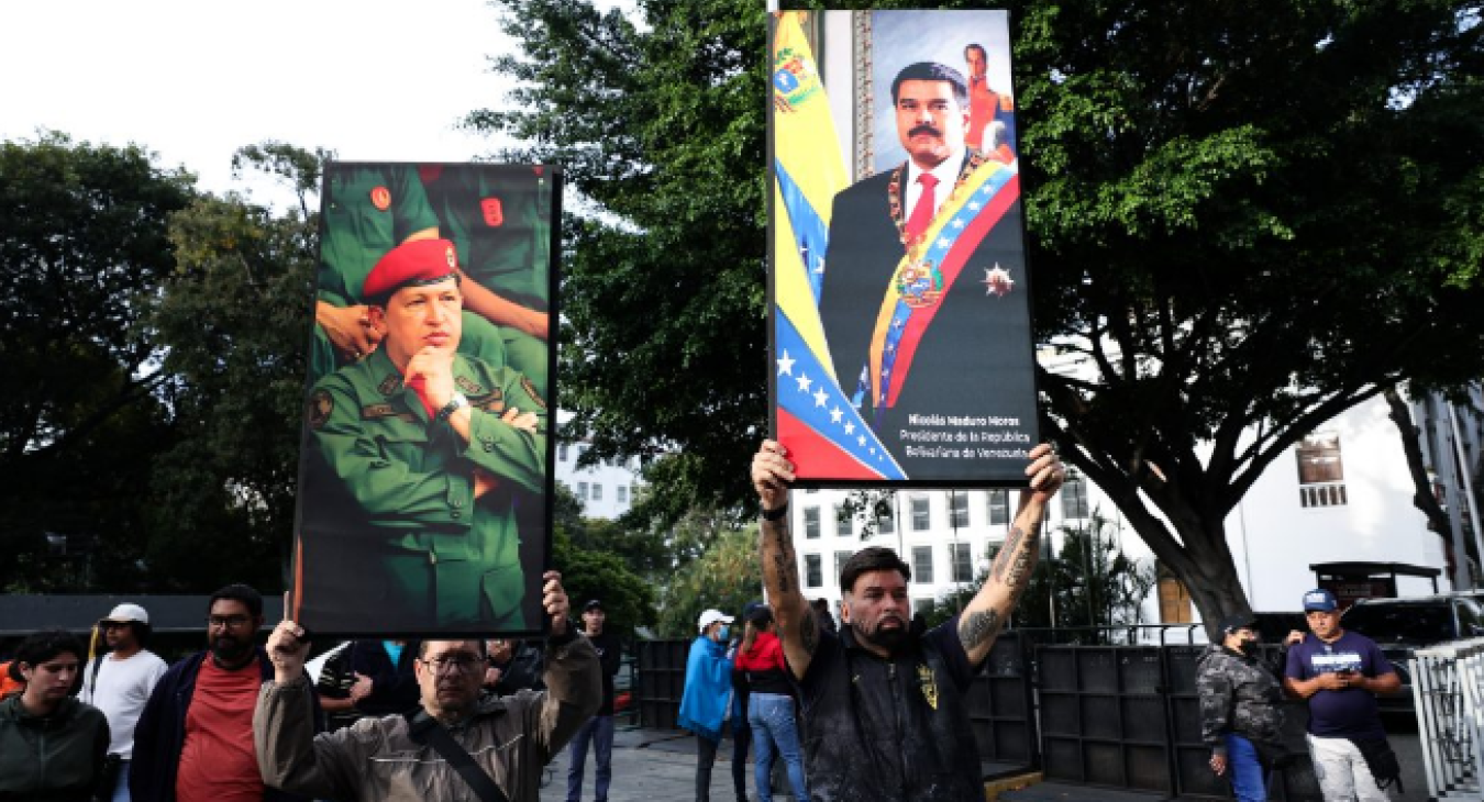 Supporters of Nicolas Maduro and late Hugo Chavez hold posters with their images
